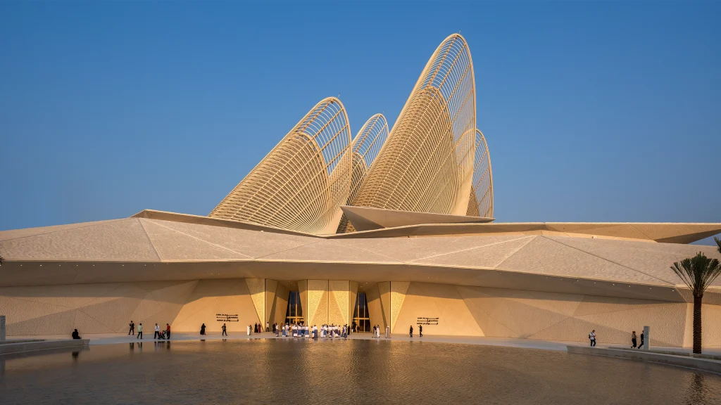 Aerial architectural photograph by Deed Studio showing Saadiyat Island in Abu Dhabi, including the Abrahamic Family House, Louvre Abu Dhabi, Zayed National Museum, Guggenheim Abu Dhabi, Natural History Museum Abu Dhabi, and teamLab Phenomena, illustrating the spatial relationship between the cultural institutions.