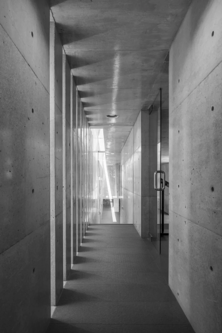 Deed Studio, an award-winning architecture photography studio based in Dubai and the GCC, captures the Koshino House by Tadao Ando—a minimalist concrete home set into a wooded hillside, defined by curved and rectilinear forms and soft natural light filtering through narrow skylights