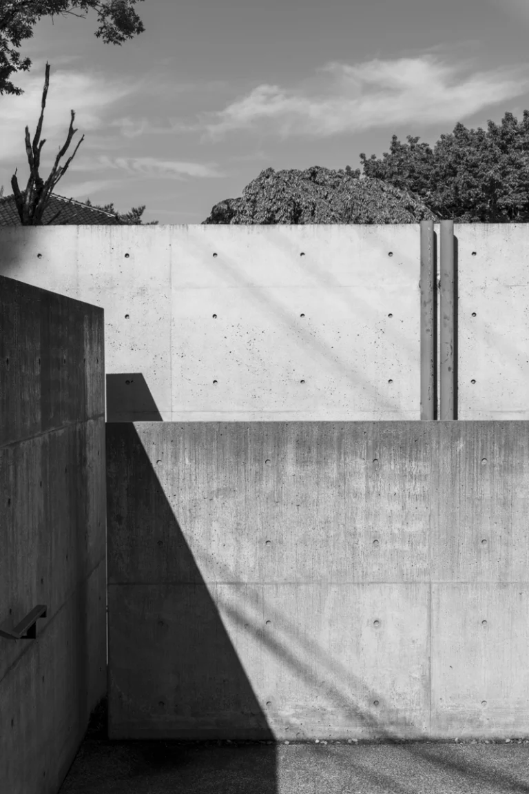 Deed Studio, an award-winning architecture photography studio based in Dubai and the GCC, captures the Koshino House by Tadao Ando—a minimalist concrete home set into a wooded hillside, defined by curved and rectilinear forms and soft natural light filtering through narrow skylights