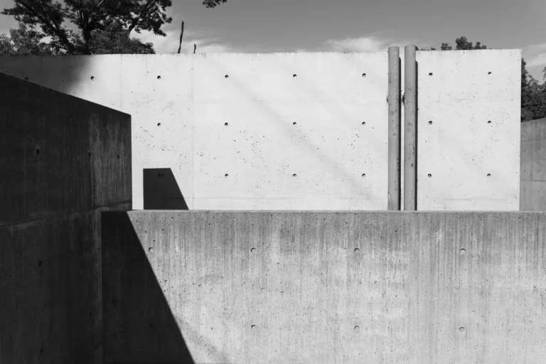 Deed Studio, an award-winning architecture photography studio based in Dubai and the GCC, captures the Koshino House by Tadao Ando—a minimalist concrete home set into a wooded hillside, defined by curved and rectilinear forms and soft natural light filtering through narrow skylights