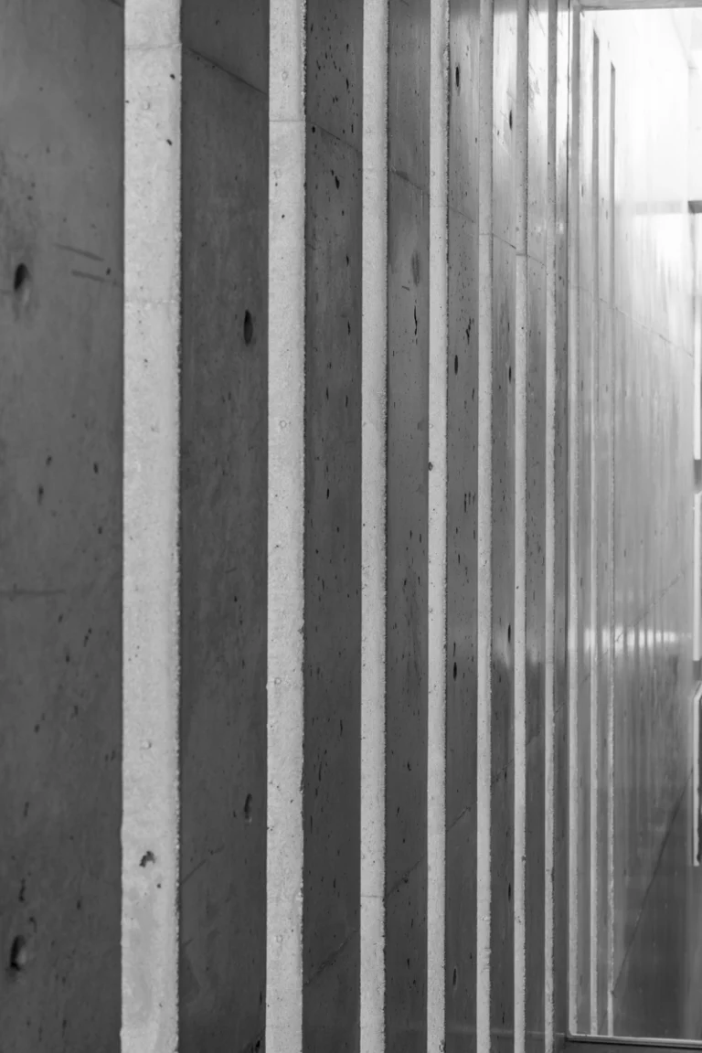 Deed Studio, an award-winning architecture photography studio based in Dubai and the GCC, captures the Koshino House by Tadao Ando—a minimalist concrete home set into a wooded hillside, defined by curved and rectilinear forms and soft natural light filtering through narrow skylights