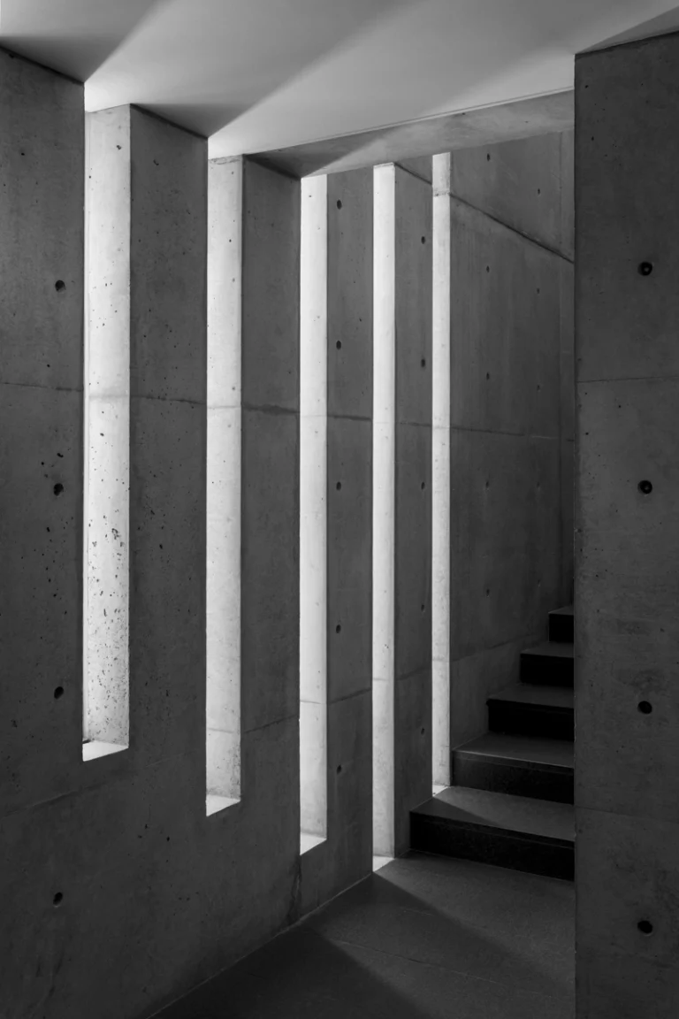 Deed Studio, an award-winning architecture photography studio based in Dubai and the GCC, captures the Koshino House by Tadao Ando—a minimalist concrete home set into a wooded hillside, defined by curved and rectilinear forms and soft natural light filtering through narrow skylights