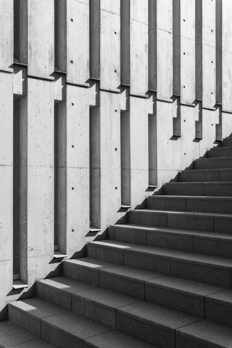 Deed Studio, an award-winning architecture photography studio based in Dubai and the GCC, captures the Koshino House by Tadao Ando—a minimalist concrete home set into a wooded hillside, defined by curved and rectilinear forms and soft natural light filtering through narrow skylights
