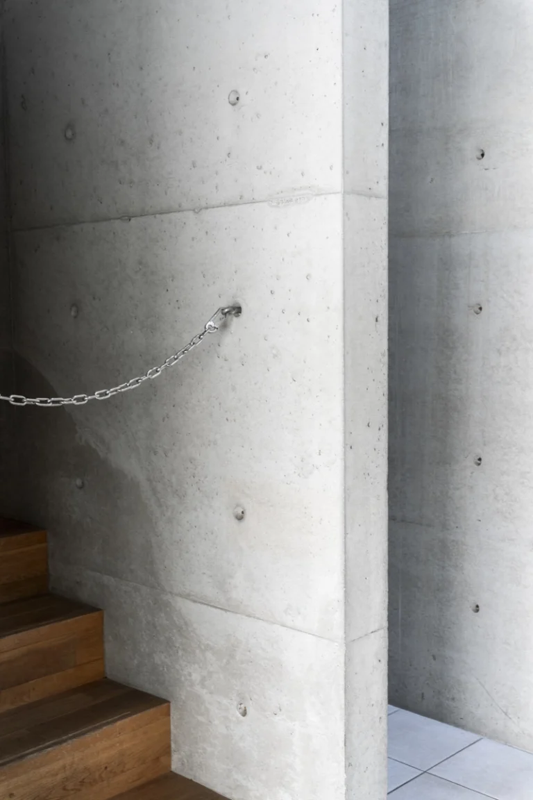 Deed Studio, an award-winning architecture photography studio based in Dubai and the GCC, captures the Koshino House by Tadao Ando—a minimalist concrete home set into a wooded hillside, defined by curved and rectilinear forms and soft natural light filtering through narrow skylights