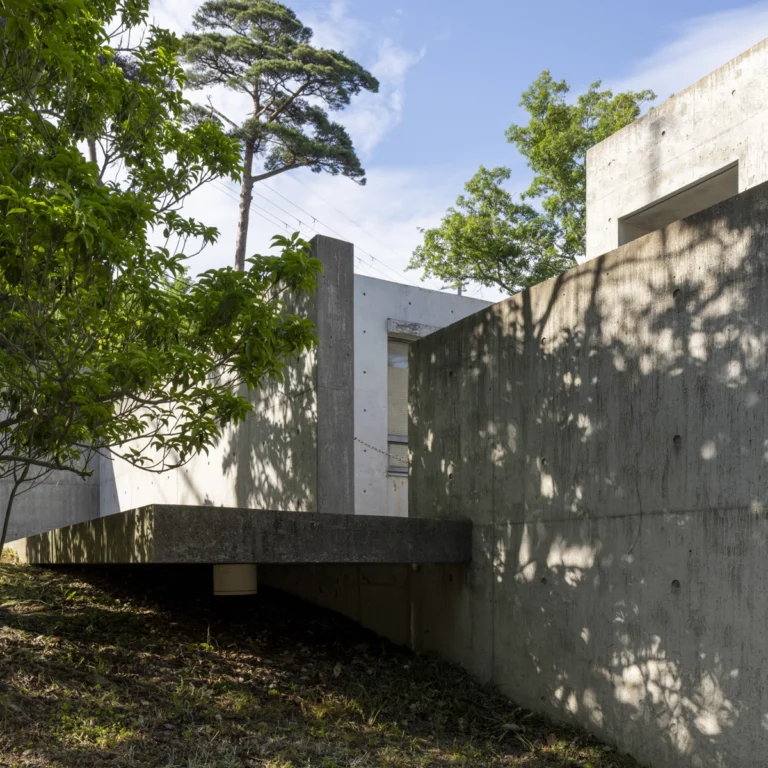 Deed Studio, an award-winning architecture photography studio based in Dubai and the GCC, captures the Koshino House by Tadao Ando—a minimalist concrete home set into a wooded hillside, defined by curved and rectilinear forms and soft natural light filtering through narrow skylights